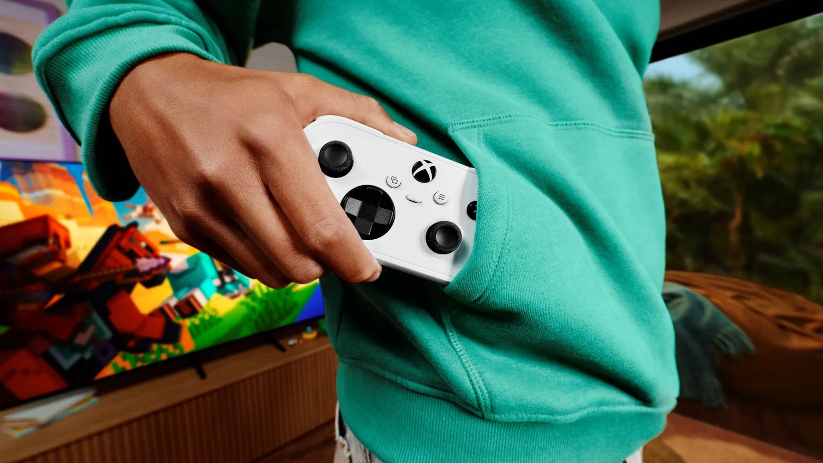 A person sliding the white XBOX Nano Controller into a hoodie pocket